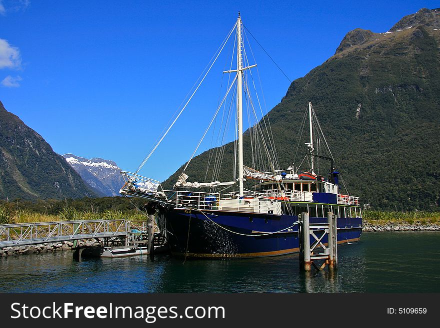 A traditional sailing boat docked at a harbour. A traditional sailing boat docked at a harbour.