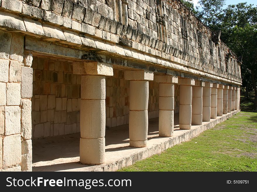 Row of antique maya columns with green grass. Row of antique maya columns with green grass