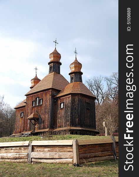 Wooden Orthodox church in bare spring park, old dark timber walls, domes, roofs weathered, Pirogovo, Kiev, Ukraine. Wooden Orthodox church in bare spring park, old dark timber walls, domes, roofs weathered, Pirogovo, Kiev, Ukraine