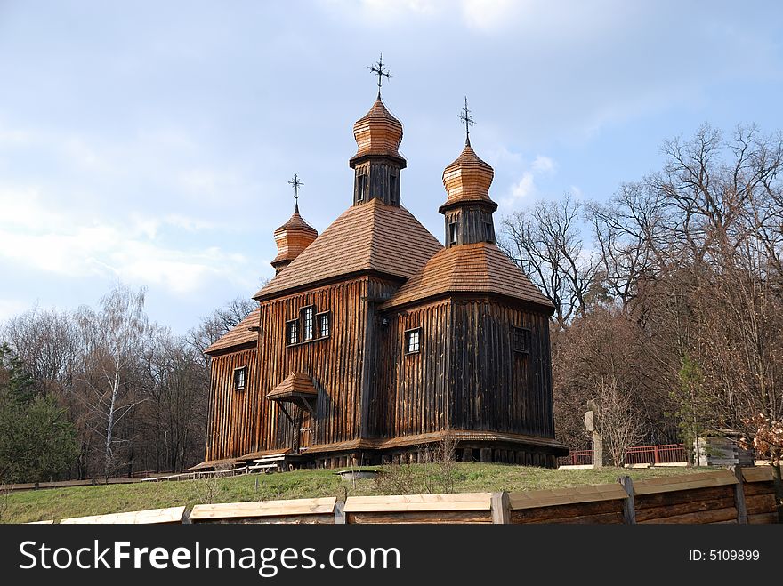 Wooden Orthodox church in bare spring park, old dark timber walls, domes, roofs weathered, Pirogovo, Kiev, Ukraine. Wooden Orthodox church in bare spring park, old dark timber walls, domes, roofs weathered, Pirogovo, Kiev, Ukraine