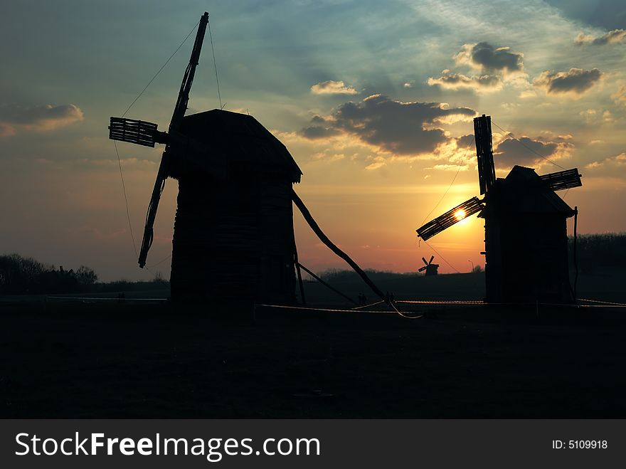 Old windmills against  sunset sky