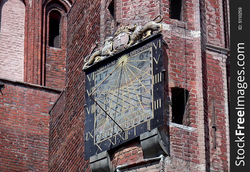 The historical sundial detail. Red brick tower in Gdańsk, Poland. The historical sundial detail. Red brick tower in Gdańsk, Poland.