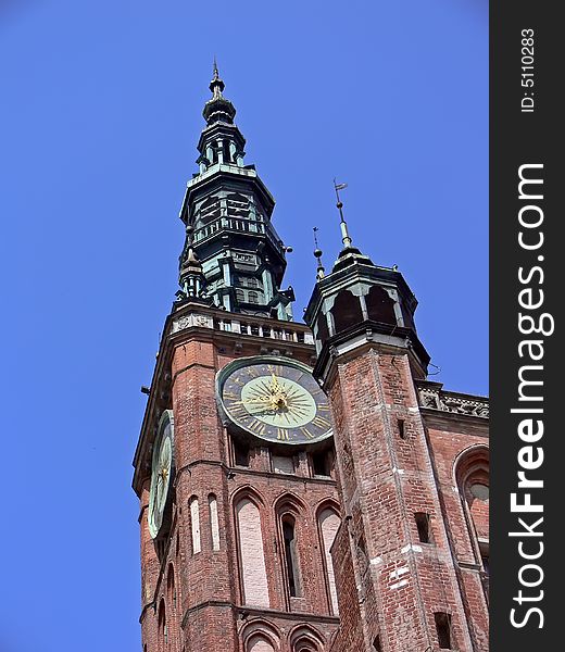 The historical building in GdaÅ„sk, Poland. Bricked tower with big clock. The historical building in GdaÅ„sk, Poland. Bricked tower with big clock.