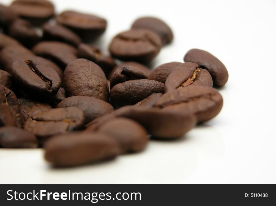 Unground coffee beans in differential focus, heaped high and isolated on pure white!. Unground coffee beans in differential focus, heaped high and isolated on pure white!