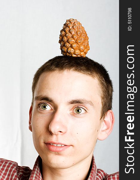 Surprised man with fir cone on the hi`s head