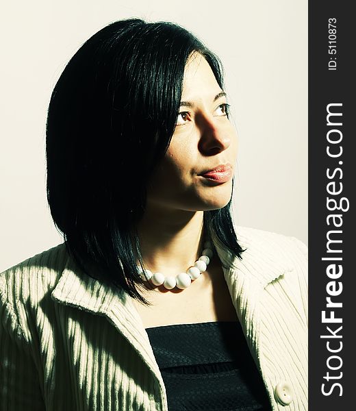 A high-key portrait about a young attractive lady with black hair who is looking up and she is dreaming. She is wearing a white coat, a black dress and a white necklace. A high-key portrait about a young attractive lady with black hair who is looking up and she is dreaming. She is wearing a white coat, a black dress and a white necklace.