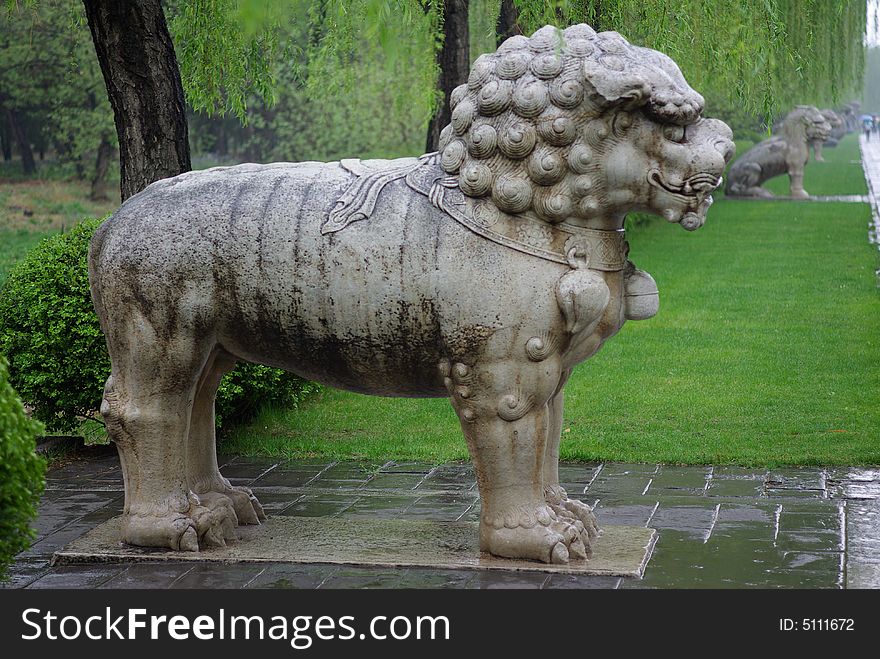 Ancient rock lion in rain