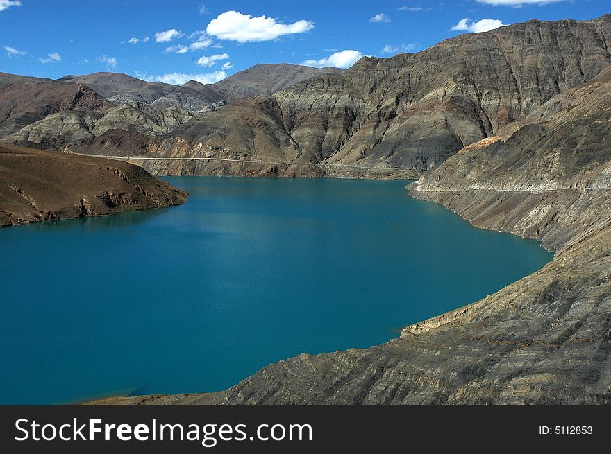 A blue plateau lake surrounded with rocky mountains.The Sheep Lake, a saint lake in Tibet,China. A blue plateau lake surrounded with rocky mountains.The Sheep Lake, a saint lake in Tibet,China.