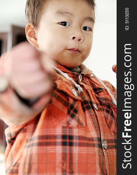 A asian boy make a cockeyed   and looking at his finger. A asian boy make a cockeyed   and looking at his finger