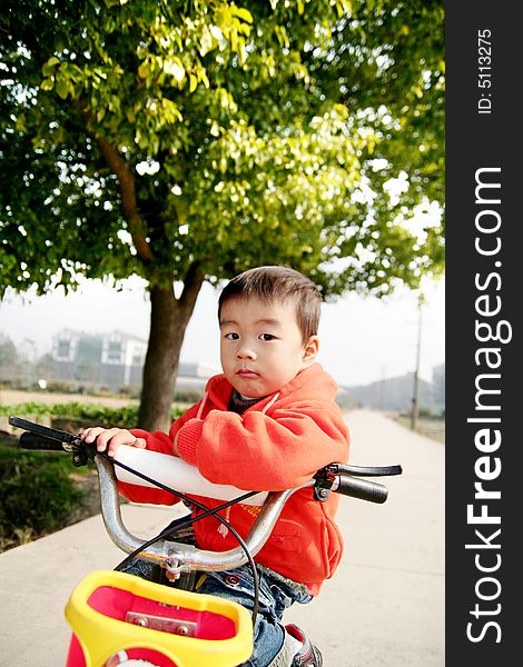 A Asian boy on his bike on road