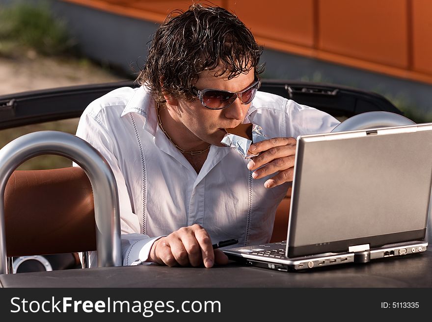 Man using a laptop outdoors. Man using a laptop outdoors