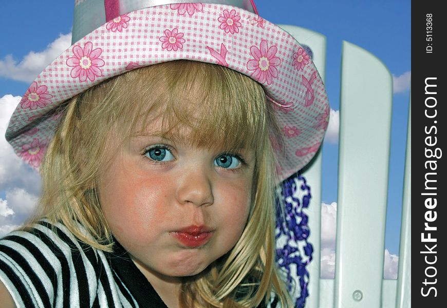 Little girl wearing her new summer hat. Little girl wearing her new summer hat.