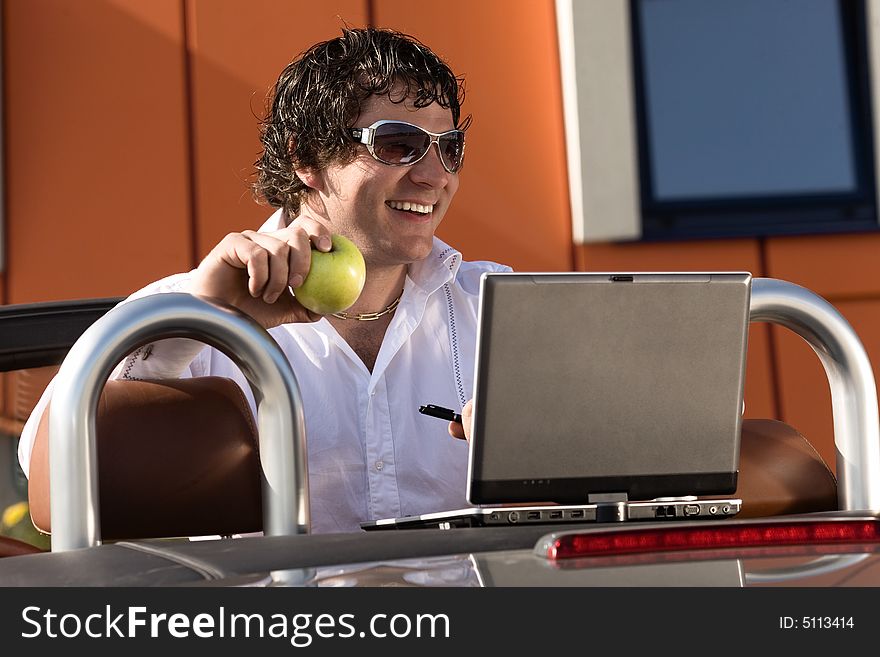 Man using a laptop outdoors. Man using a laptop outdoors