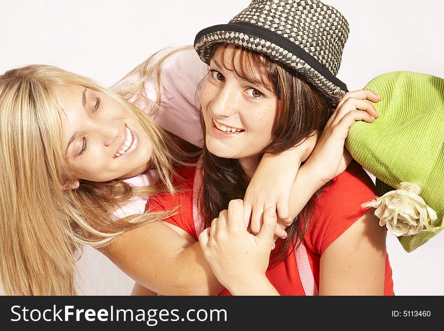 Teenagers girls playing and laughing, hugging with happiness wearing hats. Teenagers girls playing and laughing, hugging with happiness wearing hats