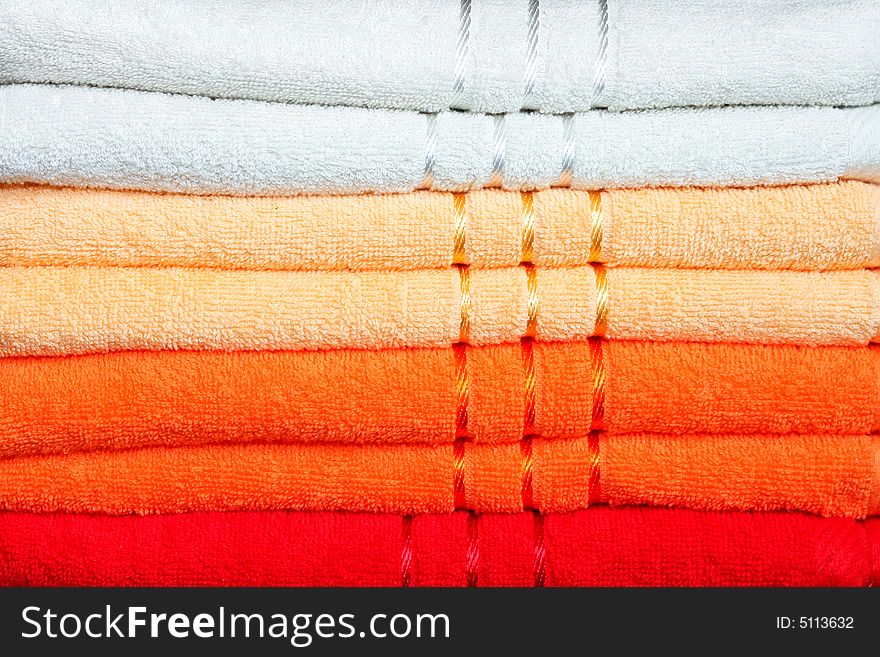 Stack of dry soft towels in warm colors. Stack of dry soft towels in warm colors