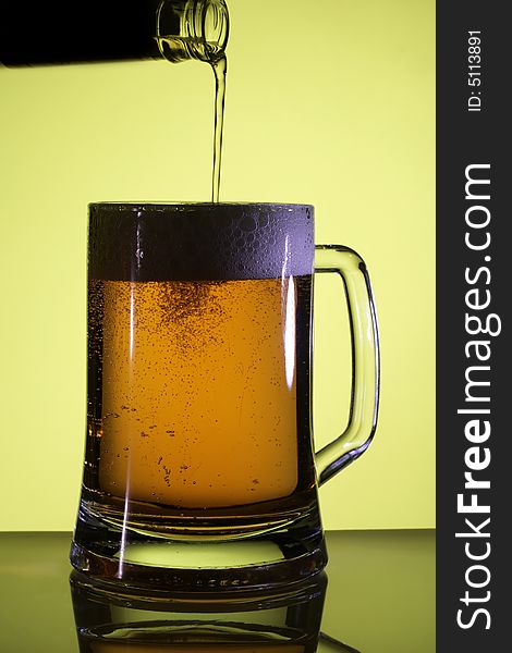 Beer in a glass. Yellow light backgrounds. Beer in a glass. Yellow light backgrounds.