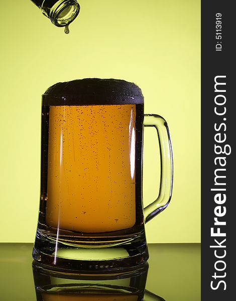 Beer in a glass. Yellow light backgrounds. Beer in a glass. Yellow light backgrounds.