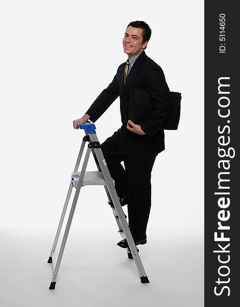 Businessman smiling as he climbs up a stepladder, briefcase in hand. Isolated against a white background. Businessman smiling as he climbs up a stepladder, briefcase in hand. Isolated against a white background