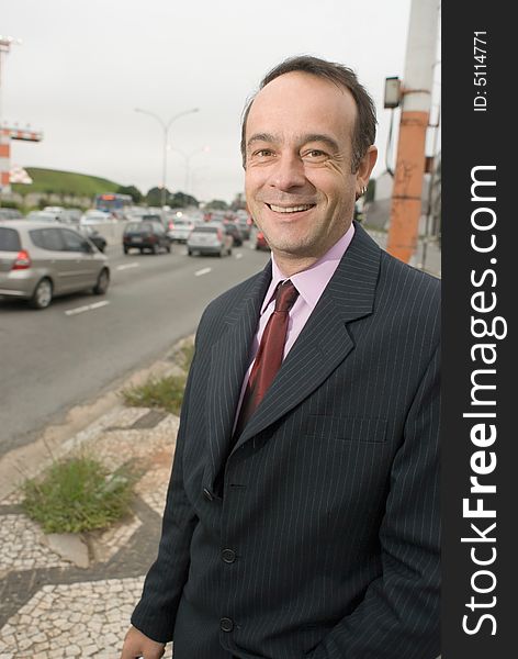 A shot of a businessman standing by a road. A shot of a businessman standing by a road.