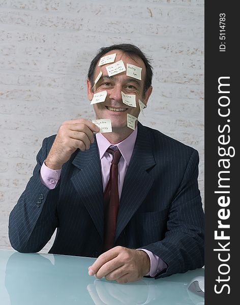 Smiling businessman staying organized using sticky notes. On himself.