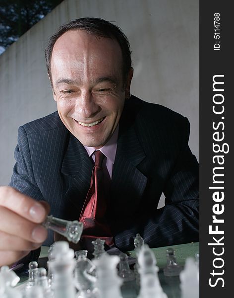 A close-up shot of a businessman playing with chess pieces.