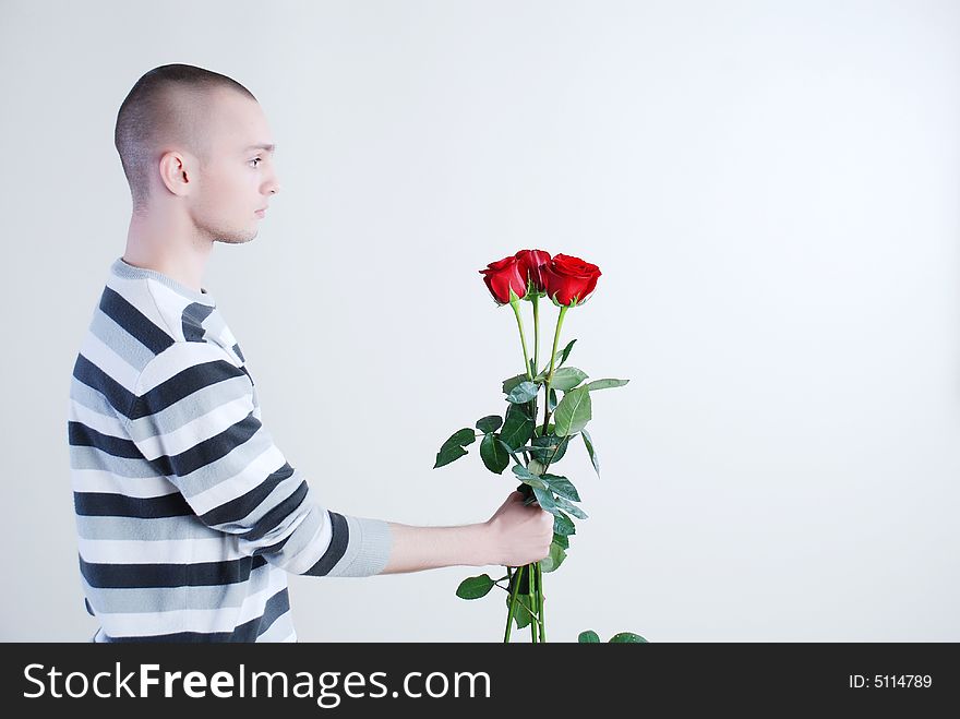 Young man with red roses at white background. Young man with red roses at white background