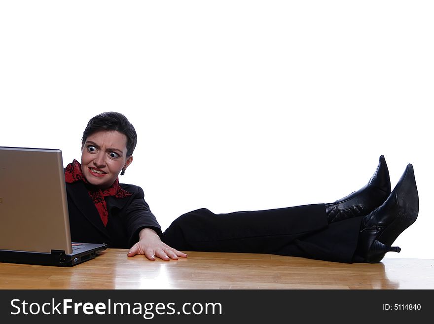 An isolated shot, on white, of a businesswoman using computer with her feet up on the desk. Her face is showing the expression of disbelief or surprise. An isolated shot, on white, of a businesswoman using computer with her feet up on the desk. Her face is showing the expression of disbelief or surprise.