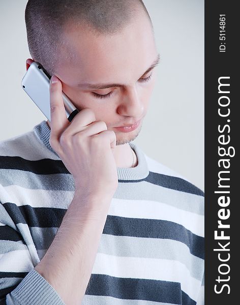 Young man talking by phone at white background