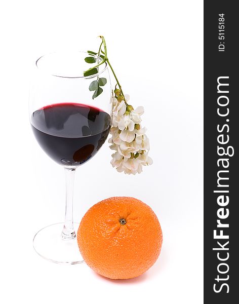 A glass of red wine vith flower and orange on the white background. A glass of red wine vith flower and orange on the white background