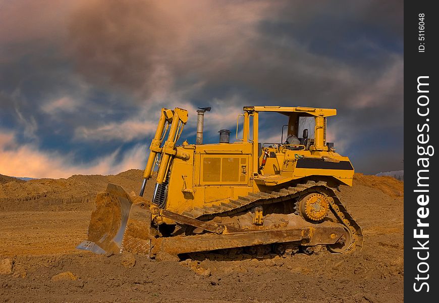 Large bulldozer with a dramatic sky in the background