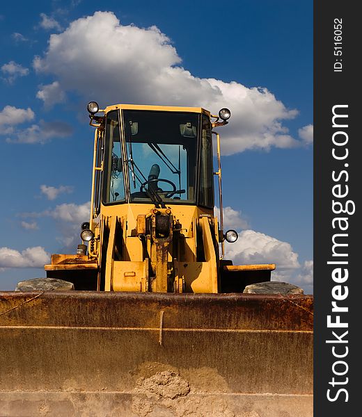 Bulldozer from the front with cloudy sky background