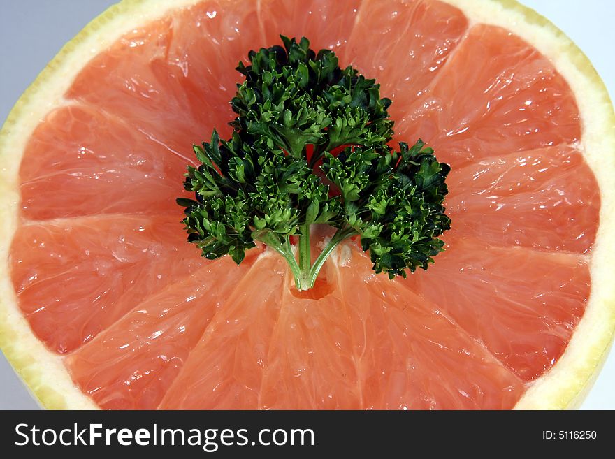 Half of a grapefruit with parsley in center. Half of a grapefruit with parsley in center