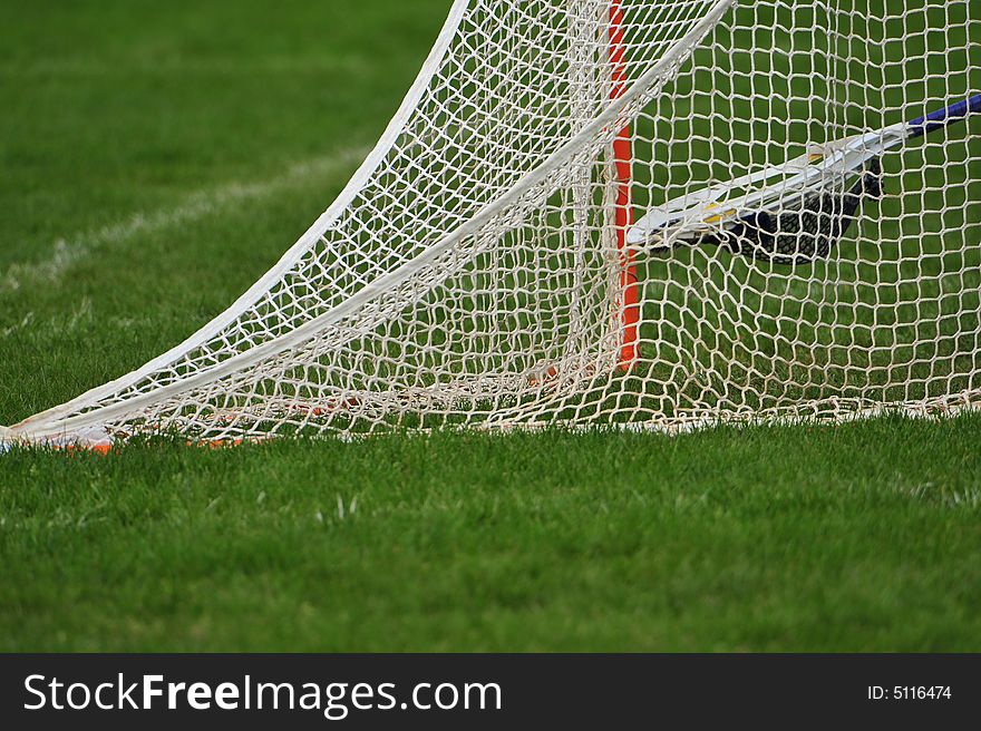 High school girls Lacrosse retrieving the ball after a goal.