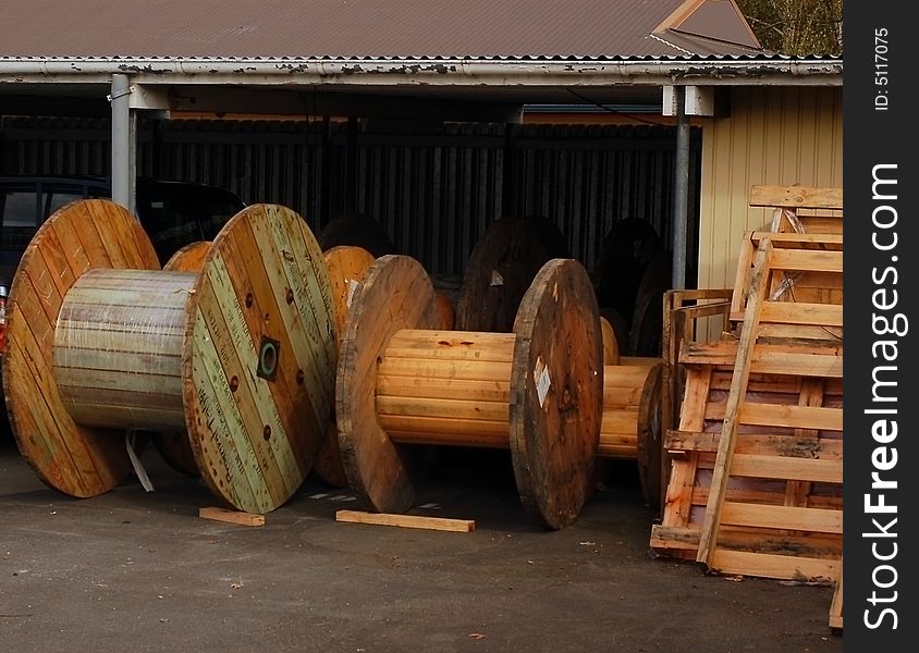 Yard with old wooden cable drums and odd scraps of lumber. Yard with old wooden cable drums and odd scraps of lumber