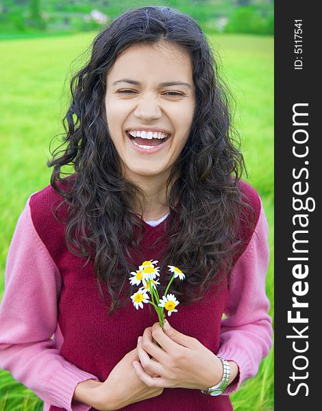 Happy young woman in green field of wheat, holding flowers. Happy young woman in green field of wheat, holding flowers