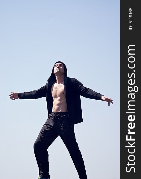 Young man with naked chest in the hood with sky background. Young man with naked chest in the hood with sky background