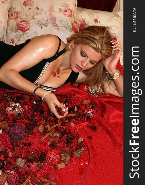 Beautiful blonde woman laying on a red sheet bed. Beautiful blonde woman laying on a red sheet bed