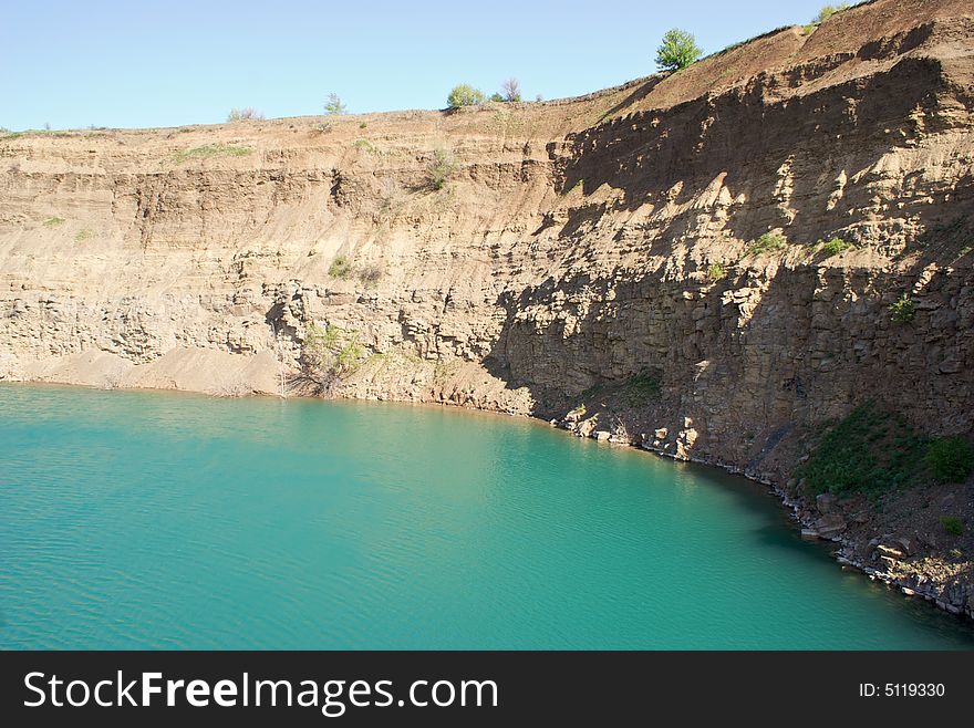 Deep lake near rocks and tree