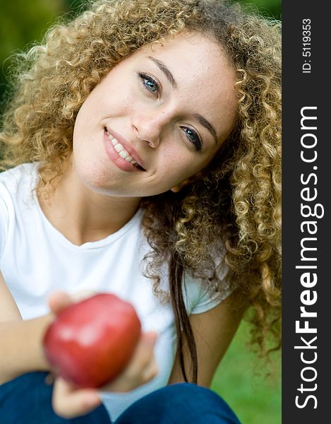 A young attractive woman holding an apple