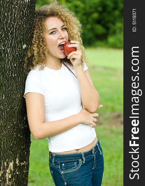 A young attractive woman holding an apple