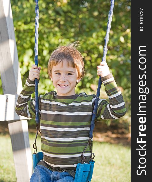 Little Boy Swinging Outdoors on a Sunny Day
