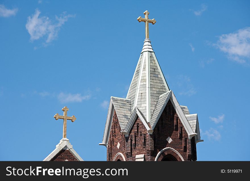 Two Church Steeples Against a Blue Cloudy Sky