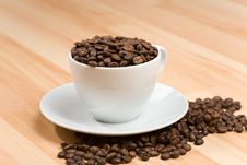 Free Cup With Coffee Beans On Hardwood Floor Royalty Free Stock Photo - 5120355