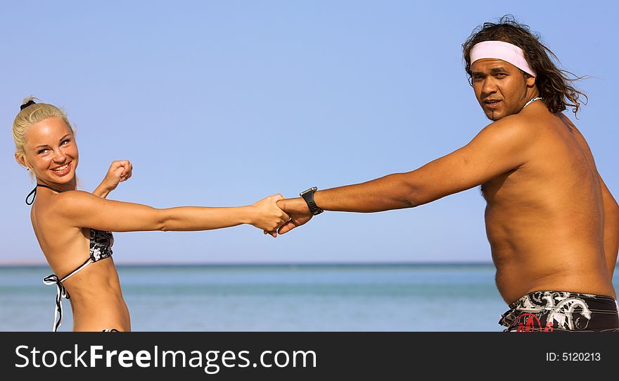 A young couple running on the beach in summer. A young couple running on the beach in summer