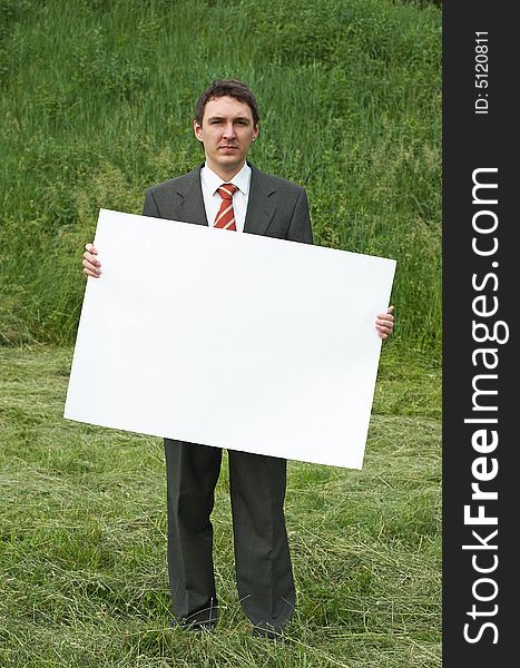 Businessman holding sheet of paper outdoor