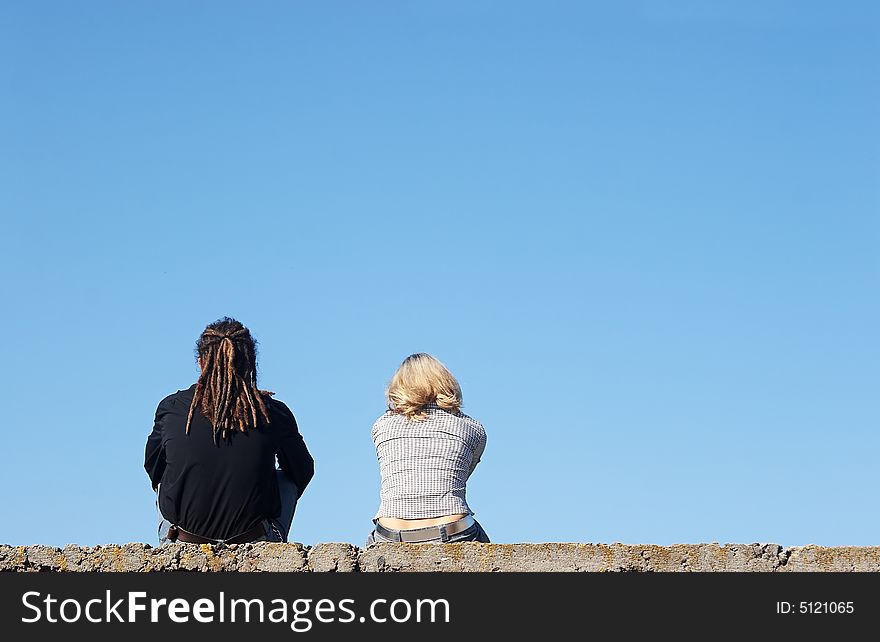 Couple sitting under the blue sky. Couple sitting under the blue sky