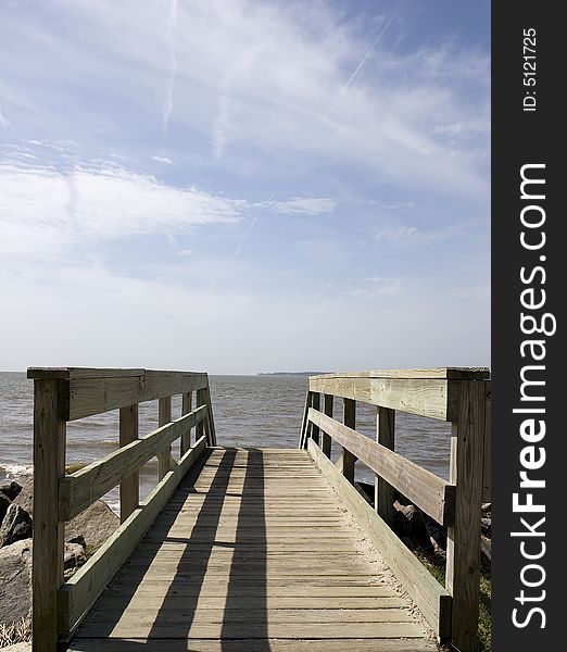 An old weathered bridge across a seawall toward the ocean. An old weathered bridge across a seawall toward the ocean.