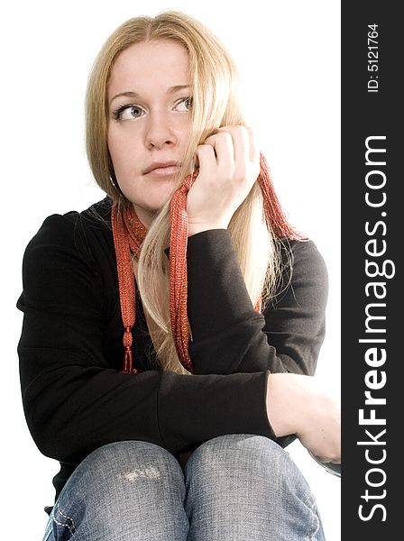 Pretty blonde in black coat, blue jeans and red scarf on white