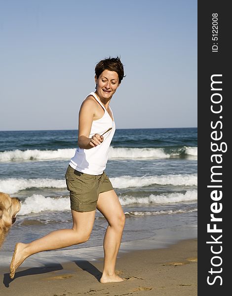 Young girl and dog playing on the beach