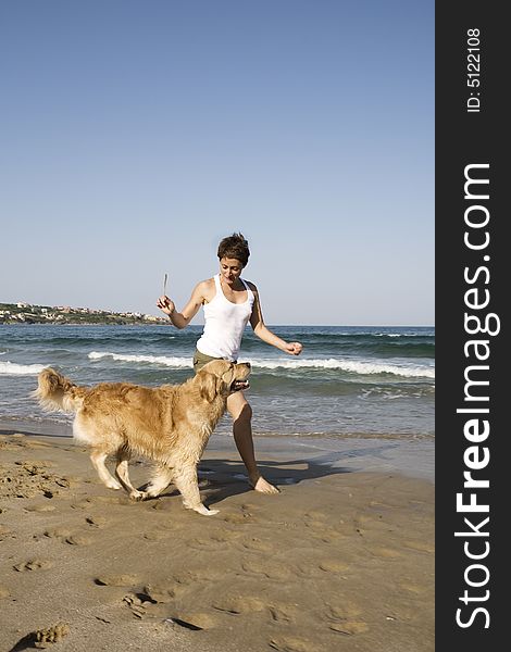Young girl and dog playing on the beach